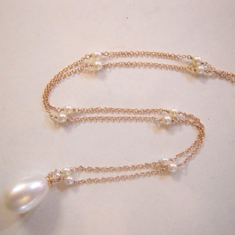 Giro collo battesimo, in oro rosa 750/000, con catena rollò inframezzata da piccole perle, con ciondolo di perla a goccia.
